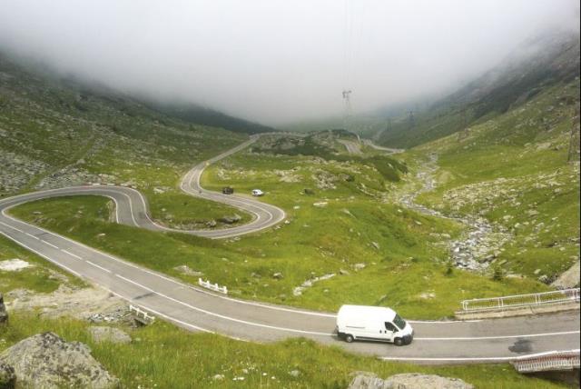 A van drives along the snaking road ascending the Fagaras Mountains (photo credit: LAURA KELLY)