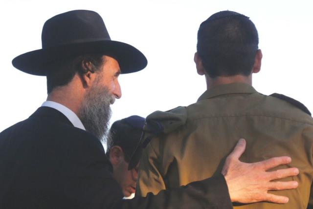 A haredi man embraces a youth from the Orthodox community who has joined the army (photo credit: MARC ISRAEL SELLEM)